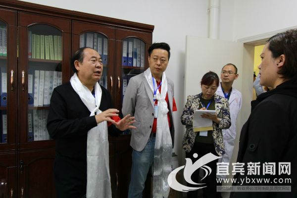 谢明均（左一）现场为新龙县人民医院建设“把脉”。（宜宾新闻网 龙亿江 摄）