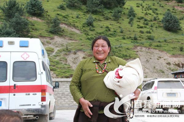 在领取到衣服后，藏族妇女开心的笑了。（宜宾新闻网 龙亿江 摄）