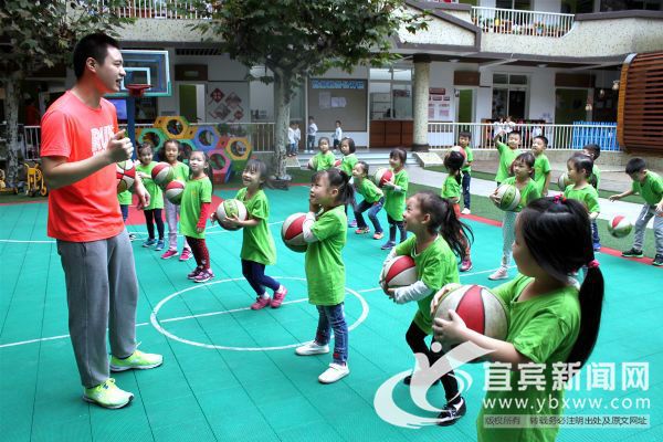 孩子们在幼儿园老师的指导下进行户外球操活动。（宜宾新闻网 刘佳 摄）